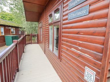 A wooden deck with railing outside a cabin marked Tanglewood 15 Thirlmere at Tanglewood Lodge Thirlmere 15 White Cross Bay near Windermere