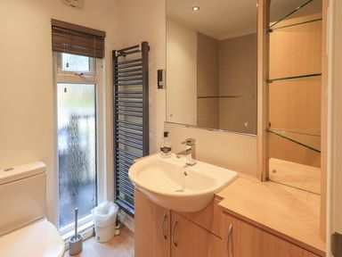 A bathroom with a toilet sink mirror towel rack and window at Forest Pines Lodge Beech Hill 10 Fallbarrow Park near Bowness on Windermere