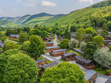 A village with wooden lodges surrounded by trees and hills at Birthwaite Lodge in Fellside 6 Limefitt Park near Windermere