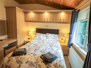 A bedroom with a bed and bedside table at Birthwaite Lodge, Fellside 6, Limefitt Park near Windermere