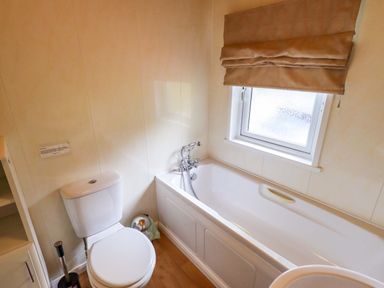 A bathroom with a toilet and bath at Birthwaite Lodge Fellside 6, Limefitt Park near Windermere