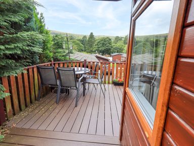 An outdoor deck with a table and chairs at Birthwaite Lodge near Fellside 6, Limefitt Park near Windermere