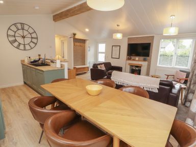 A dining room with a table and chairs at Beech Grove Lodge in Glade 17, Fallbarrow Park near Bowness on Windermere