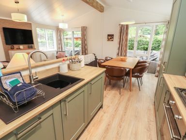 A kitchen with a dining table and chairs at Beech Grove Lodge, Glade 17, Fallbarrow Park near Bowness on Windermere