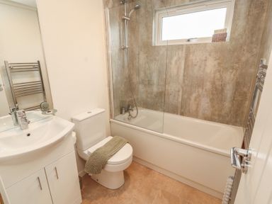 A bathroom with a bathtub and sink at Beech Grove Lodge, Glade 17, Fallbarrow Park near Bowness on Windermere