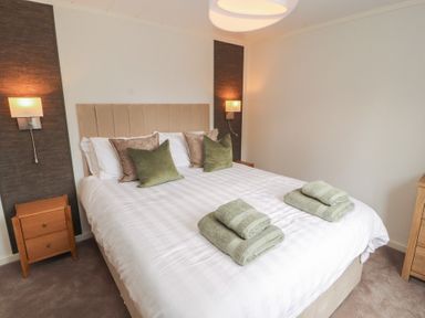 A bedroom with a bed and pillows at Beech Grove Lodge, Glade 17, Fallbarrow Park near Bowness on Windermere