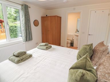 A bedroom with a bed and towels on it at Beech Grove Lodge, Glade 17, Fallbarrow Park near Bowness on Windermere