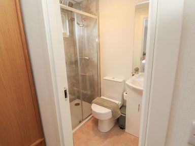 A bathroom with shower, toilet, and sink at Beech Grove Lodge in Glade 17, Fallbarrow Park near Bowness on Windermere