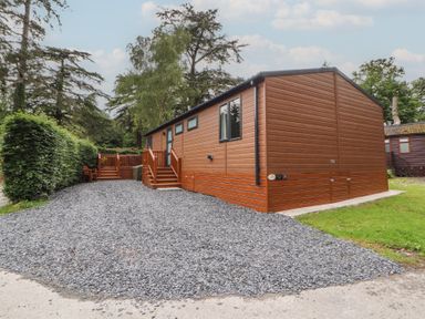 A lodge with gravel area and decking at Beech Grove Lodge, Glade 17, Fallbarrow Park near Bowness on Windermere