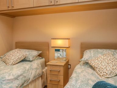 A bedroom with two single beds a nightstand and a lamp at Pheasant's Nest Kirkstone 11 Limefitt Park near Windermere