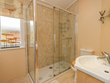 A bathroom with a shower enclosure toilet and sink at Pheasant's Nest Kirkstone 11 Limefitt Park near Windermere