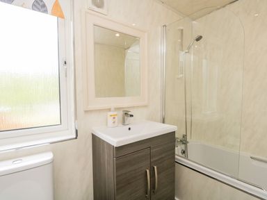 A bathroom with a sink vanity cabinet mirror shower and window at Ambleside Lodge Fellside 3 Limefitt Park near Windermere