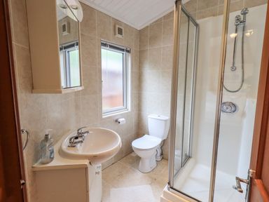 A bathroom with a sink cabinet mirror shower cubicle toilet and window at Thirlmere View Thirlmere 6 White Cross Bay near Windermere