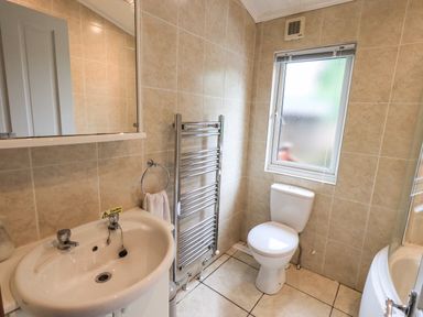 A bathroom with a sink toilet heated towel rail and frosted window at Thirlmere View Thirlmere 6 White Cross Bay near Windermere