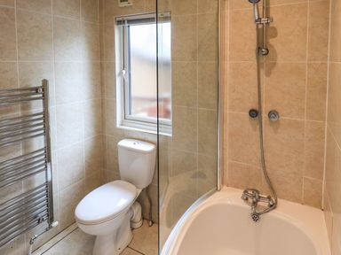 A bathroom with a toilet a bathtub with shower and a window at Thirlmere View Thirlmere 6 White Cross Bay near Windermere