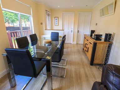A dining room with a glass table and six black chairs at Thirlmere View Thirlmere 6 White Cross Bay near Windermere