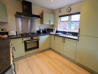 A kitchen with cabinets a stove oven microwave toaster and sink at Thirlmere View in Thirlmere 6 White Cross Bay near Windermere