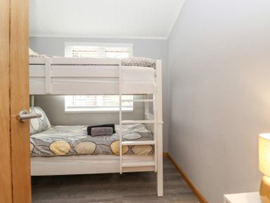 A bedroom with a white bunk bed and folded towels on the lower bed at Lakes Lodge Keswick Court 3 White Cross Bay near Windermere