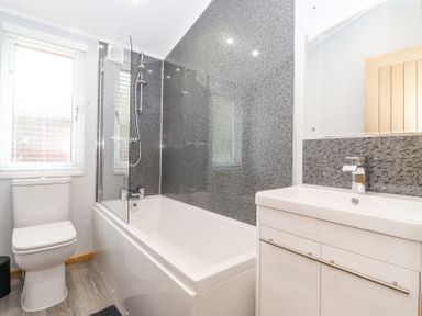 A bathroom with a toilet sink and bathtub with shower at Lakes Lodge Keswick Court 3 White Cross Bay near Windermere