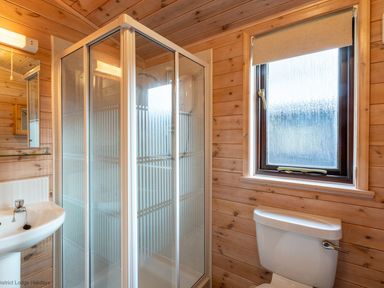 A bathroom with a shower cubicle sink toilet and window at Burr Ghyll Number 27 Burnside Park near Keswick