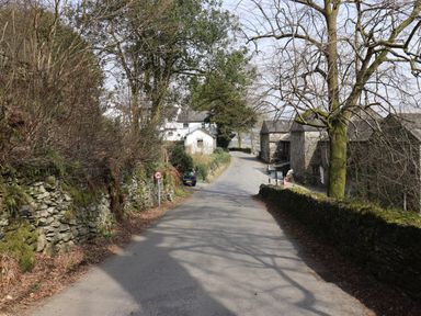 A narrow country road with stone walls trees and buildings at Ramblers Rest Lodge Pinewood 22 Limefitt Park near Windermere