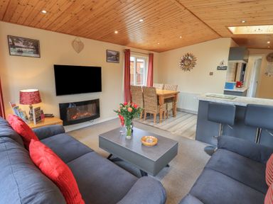 A living room with sofas and a coffee table beside a dining area at Striding Edge Lodge Ullswater 9 Limefitt Park near Windermere
