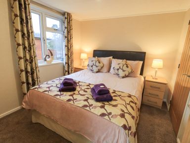 A bedroom with a bed and bedside tables with lamps at Horseshoe Lodge in Wansfell 5 Limefitt Park near Windermere