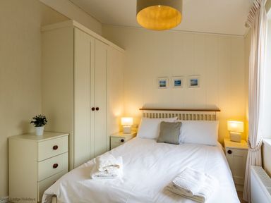 A bedroom with a bed and bedside tables with lamps at Langdale Lodge Langdale 21 White Cross Bay near Windermere