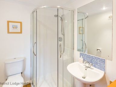 A bathroom with a toilet shower enclosure and sink at Hideaway Lodge Kirkstone 14 Limefitt Park near Windermere