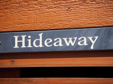 A close up of a sign with the word Hideaway on a wooden surface at Hideaway Lodge Kirkstone 14 Limefitt Park near Windermere