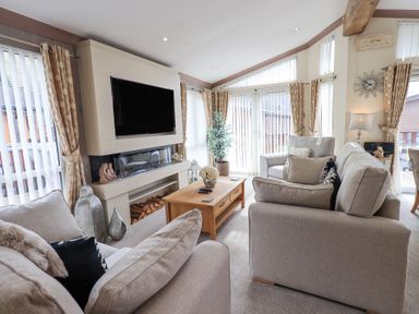 A living room with sofas a coffee table a television and a fireplace at Valley View Lodge Wansfell 10 Limefitt Park near Windermere