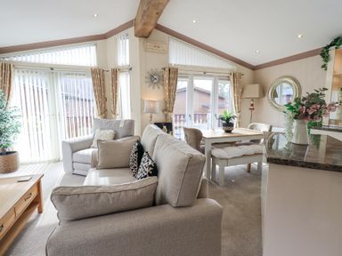 A living room with sofas a dining table and a kitchen counter at Valley View Lodge in Wansfell 10 Limefitt Park near Windermere