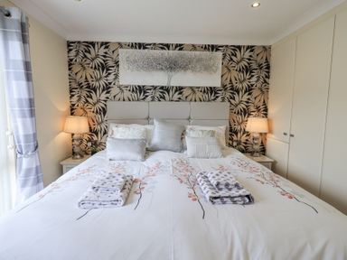 A bedroom with a double bed two bedside tables with lamps and built in wardrobes at Valley View Lodge Wansfell 10 Limefitt Park near Windermere