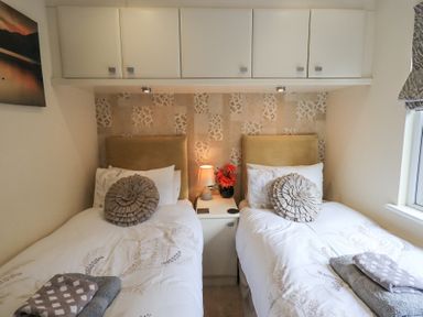 A bedroom with two single beds and a nightstand between them at Valley View Lodge Wansfell 10 Limefitt Park near Windermere