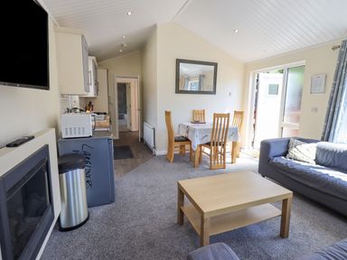 A living room with a sofa table and dining table near a kitchen area at Robin View Lodge Beckside 3 Limefitt Park near Windermere