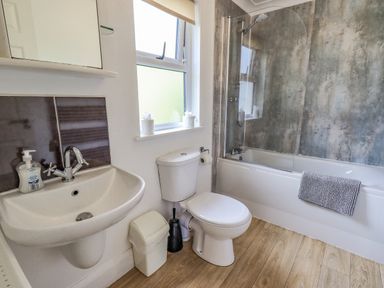 A bathroom with a sink a toilet a bathtub with a shower and a window at Robin View Lodge Beckside 3 Limefitt Park near Windermere