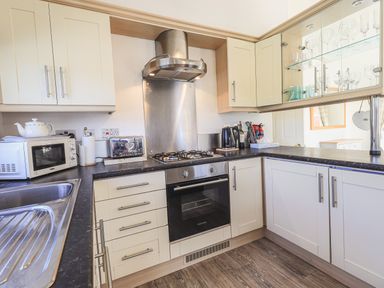 A kitchen with oven stove microwave toaster kettle and sink at Sunny Brow Lodge in Lakeside 5 White Cross Bay near Windermere