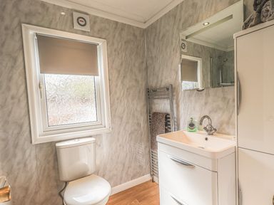 A bathroom with a toilet sink and mirror at Sunny Brow Lodge Lakeside 5 White Cross Bay near Windermere