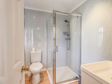A bathroom with a toilet shower enclosure and sink at Sunny Brow Lodge Lakeside 5 White Cross Bay near Windermere
