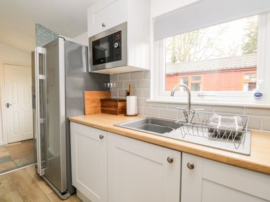 A kitchen with a stainless steel refrigerator microwave sink and wooden countertop at Badgers Hollow Lodge in Grasmere 30 White Cross Bay near Windermere