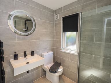 A bathroom with a sink, toilet, and shower at Badgers Hollow Lodge, Grasmere 30, White Cross Bay near Windermere