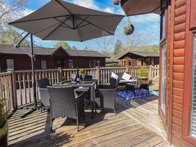 An outdoor seating area with table and chairs at Badgers Hollow Lodge Grasmere 30 White Cross Bay near Windermere