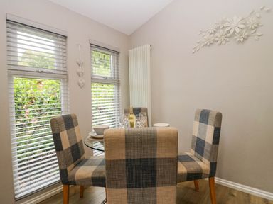 A dining room with a table and chairs at Badgers Hollow Lodge Grasmere 30 White Cross Bay near Windermere