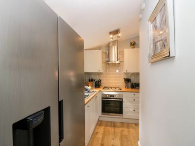 A kitchen with appliances including a refrigerator and oven at Badgers Hollow Lodge Grasmere 30, White Cross Bay near Windermere