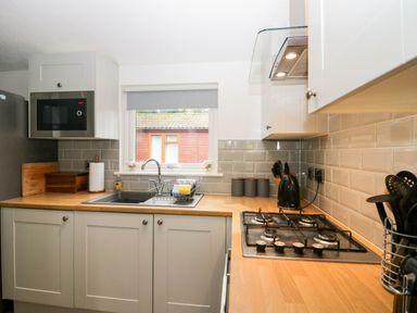 A kitchen with a sink and gas cooker at Badgers Hollow Lodge Grasmere 30, White Cross Bay near Windermere