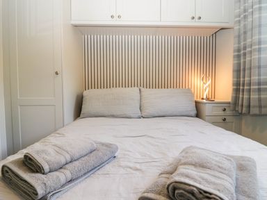 A bedroom with a bed and towels at Badgers Hollow Lodge Grasmere 30, White Cross Bay near Windermere
