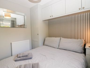 A bedroom with a bed and towels at Badgers Hollow Lodge Grasmere 30 White Cross Bay near Windermere