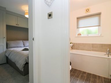 A bathroom with a bathtub and a toilet at Badgers Hollow Lodge, Grasmere 30, White Cross Bay near Windermere