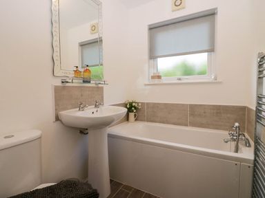 A bathroom with a sink, bathtub and toilet at Badgers Hollow Lodge Grasmere 30, White Cross Bay near Windermere