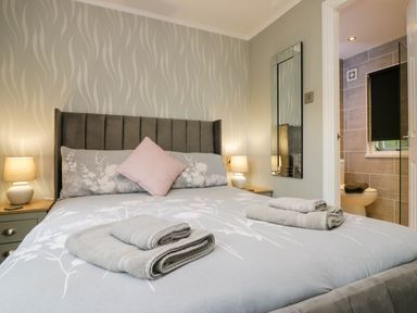 A bedroom with a bed and adjoining bathroom at Badgers Hollow Lodge Grasmere 30, White Cross Bay near Windermere